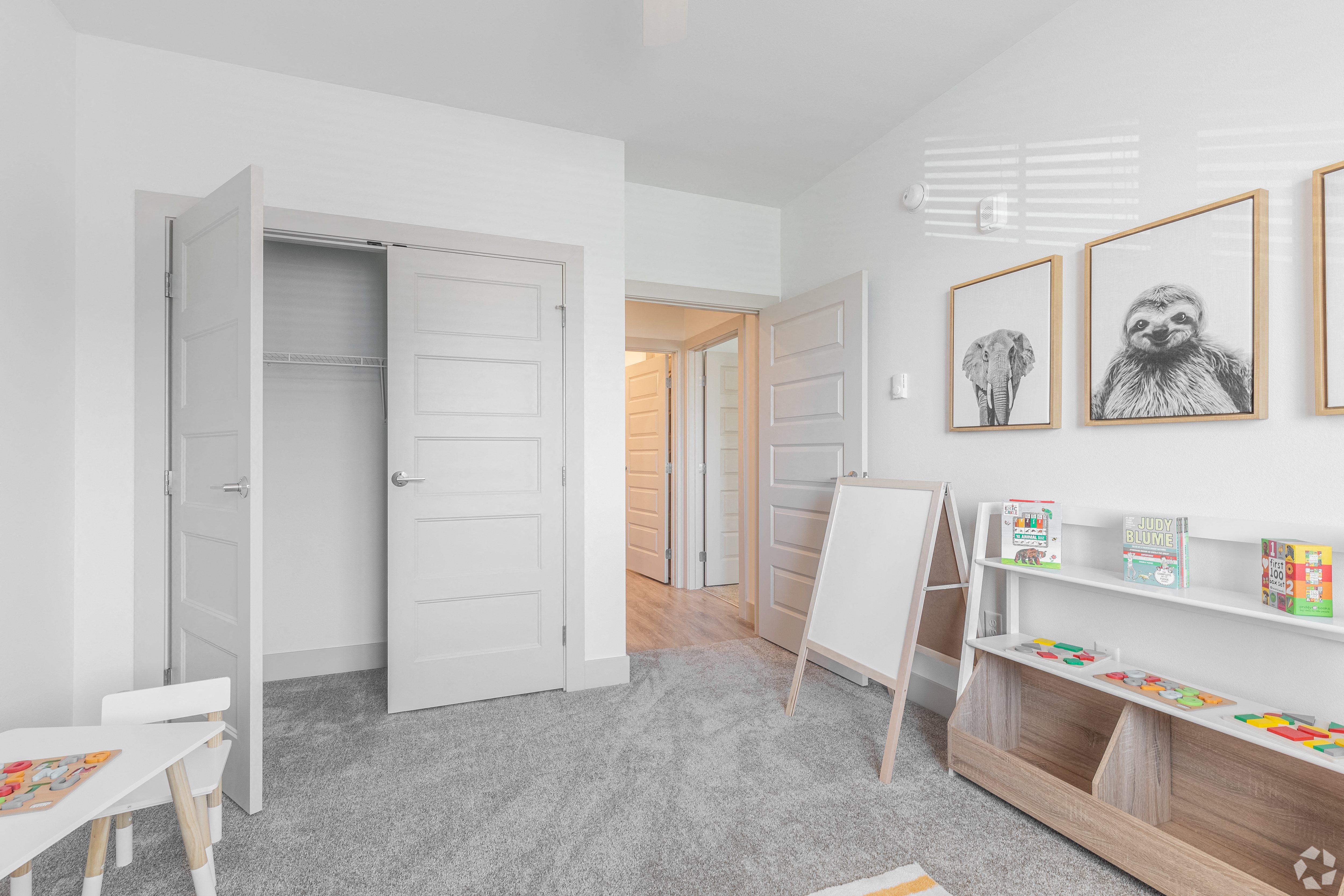 a room with an easel and paintings on the wall and a closet